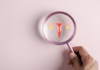 Representación holográfica del sistema reproductor femenino sostenido por un profesional médico, destacando el útero y los ovarios.
