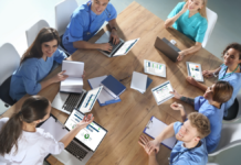 Alumnos de medicina utilizan Practicum Script en diferentes dispositivos alrededor de una mesa de trabajo.